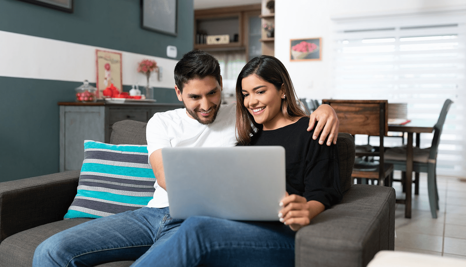 familia de 3 sonriendo mientras miran una laptop